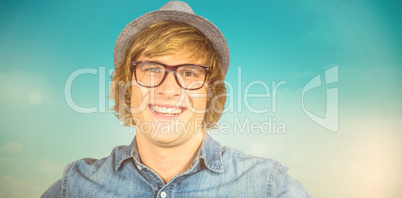 Composite image of smiling blond hipster staring at camera
