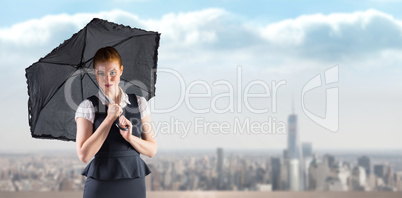 Composite image of pretty redhead businesswoman holding umbrella