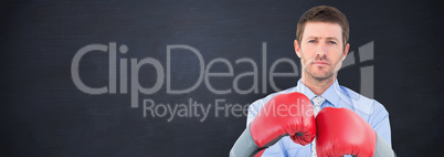 Composite image of businessman with boxing gloves