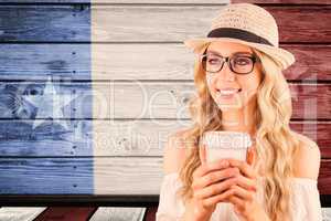 Composite image of gorgeous smiling blonde hipster holding take-