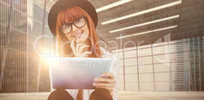Composite image of smiling hipster woman using her tablet