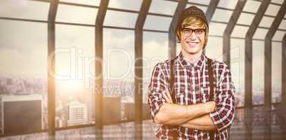 Composite image of smiling blond hipster crossing arms