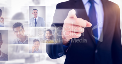 Composite image of businessman pointing his finger at camera