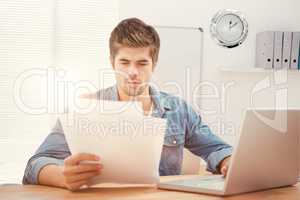 Composite image of hipster looking at documents while sitting at