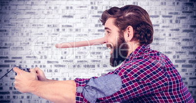 Composite image of side view of happy hipster playing video game