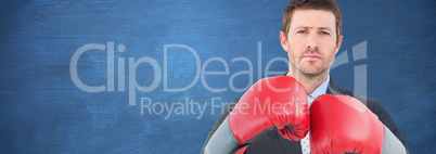 Composite image of businessman with boxing gloves