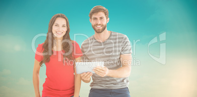 Composite image of couple posing with tablet