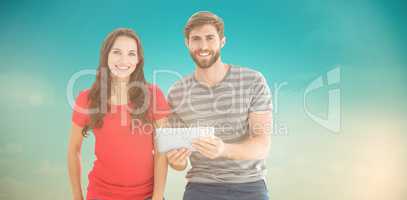 Composite image of couple posing with tablet