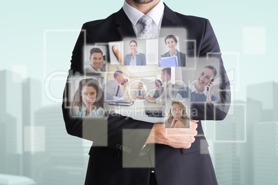 Composite image of mid section of businessman holding computer