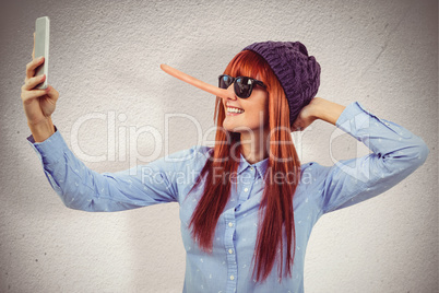 Composite image of smiling hipster woman taking selfie