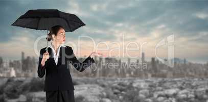 Composite image of young businesswoman holding umbrella