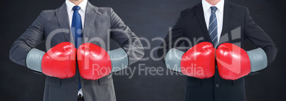 Composite image of businessman with boxing gloves