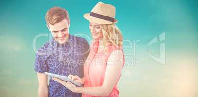 Composite image of happy couple using tablet