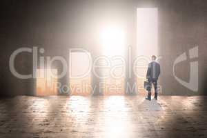 Composite image of businessman in suit looking through binocular