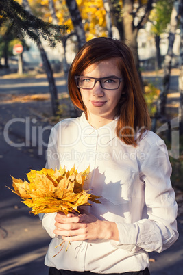teenage girl with bundle of maple leaves
