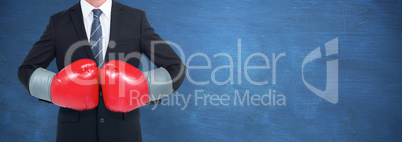 Composite image of businessman with boxing gloves