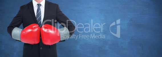 Composite image of businessman with boxing gloves