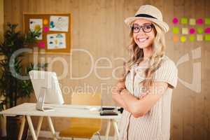 Composite image of gorgeous smiling blonde hipster with arms cro