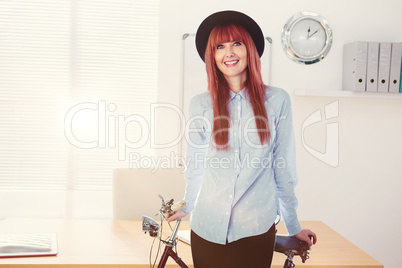 Composite image of smiling hipster woman leaning on a bike