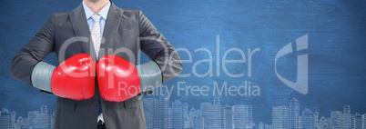 Composite image of businessman with boxing gloves