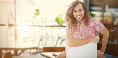 Composite image of portrait of hipster smiling while sitting on