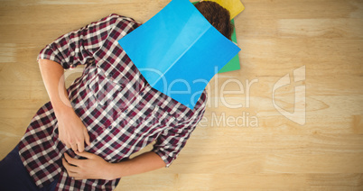 Composite image of creative businessman lying on hardwood floor