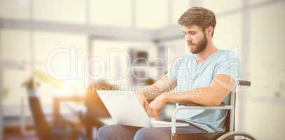 Composite image of man in wheelchair using computer