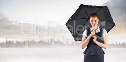 Composite image of pretty redhead businesswoman holding umbrella