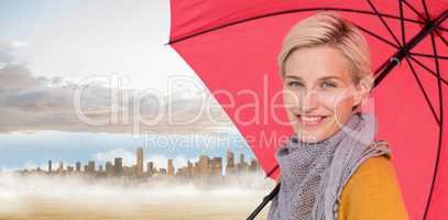 Composite image of smiling woman holding an umbrella