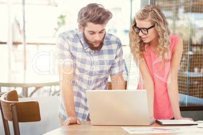 Composite image of man using laptop while discussing with woman