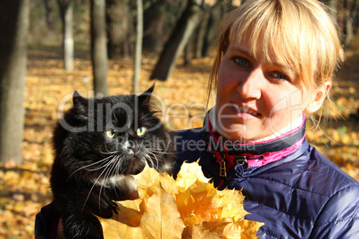 pretty modern woman with black cat in the park