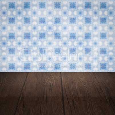 Wood table top and blur vintage ceramic tile pattern wall