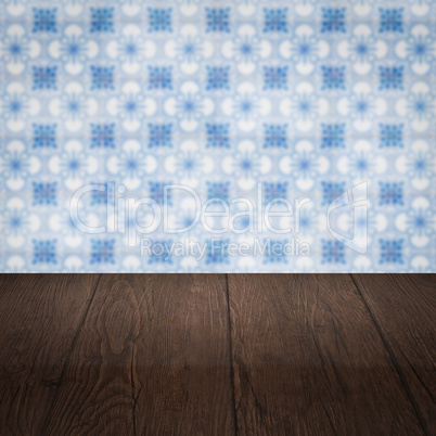 Wood table top and blur vintage ceramic tile pattern wall
