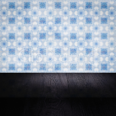 Wood table top and blur vintage ceramic tile pattern wall