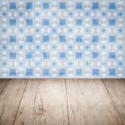 Wood table top and blur vintage ceramic tile pattern wall