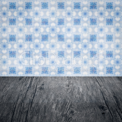 Wood table top and blur vintage ceramic tile pattern wall