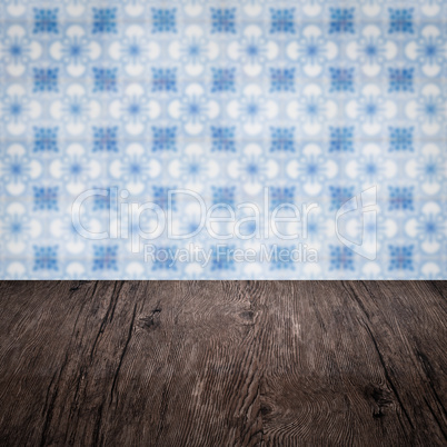 Wood table top and blur vintage ceramic tile pattern wall