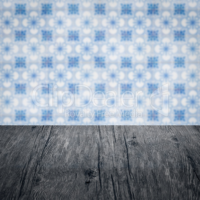 Wood table top and blur vintage ceramic tile pattern wall