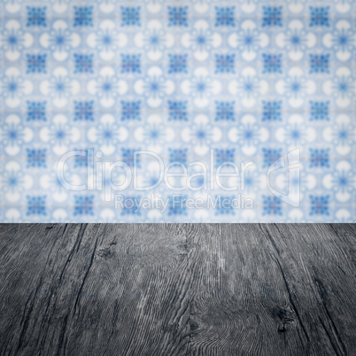 Wood table top and blur vintage ceramic tile pattern wall