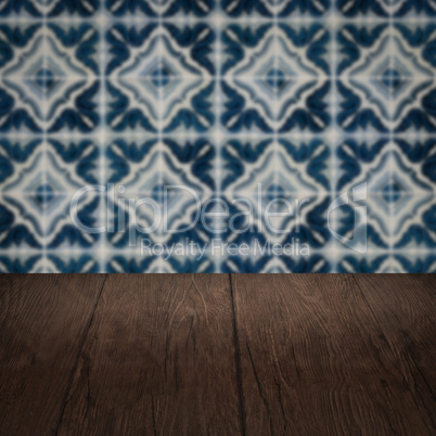 Wood table top and blur vintage ceramic tile pattern wall