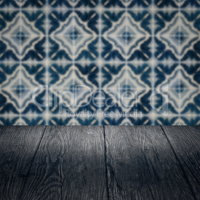 Wood table top and blur vintage ceramic tile pattern wall