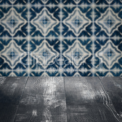 Wood table top and blur vintage ceramic tile pattern wall