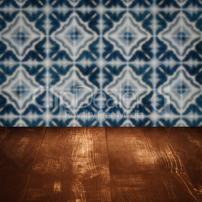 Wood table top and blur vintage ceramic tile pattern wall