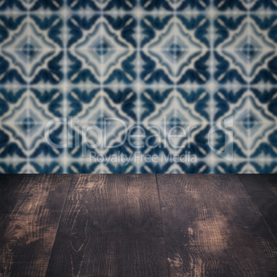 Wood table top and blur vintage ceramic tile pattern wall