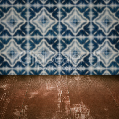 Wood table top and blur vintage ceramic tile pattern wall Wood table top and blur vintage ceramic tile pattern wall