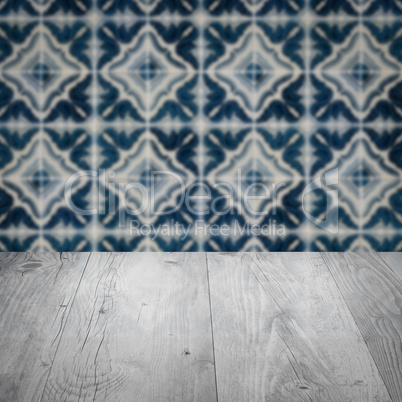 Wood table top and blur vintage ceramic tile pattern wall