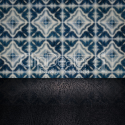 Wood table top and blur vintage ceramic tile pattern wall