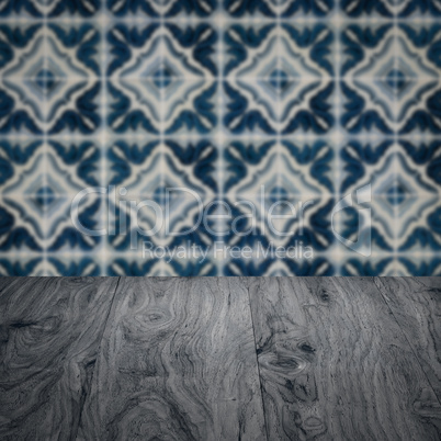 Wood table top and blur vintage ceramic tile pattern wall