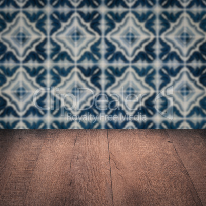 Wood table top and blur vintage ceramic tile pattern wall