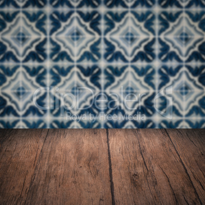 Wood table top and blur vintage ceramic tile pattern wall